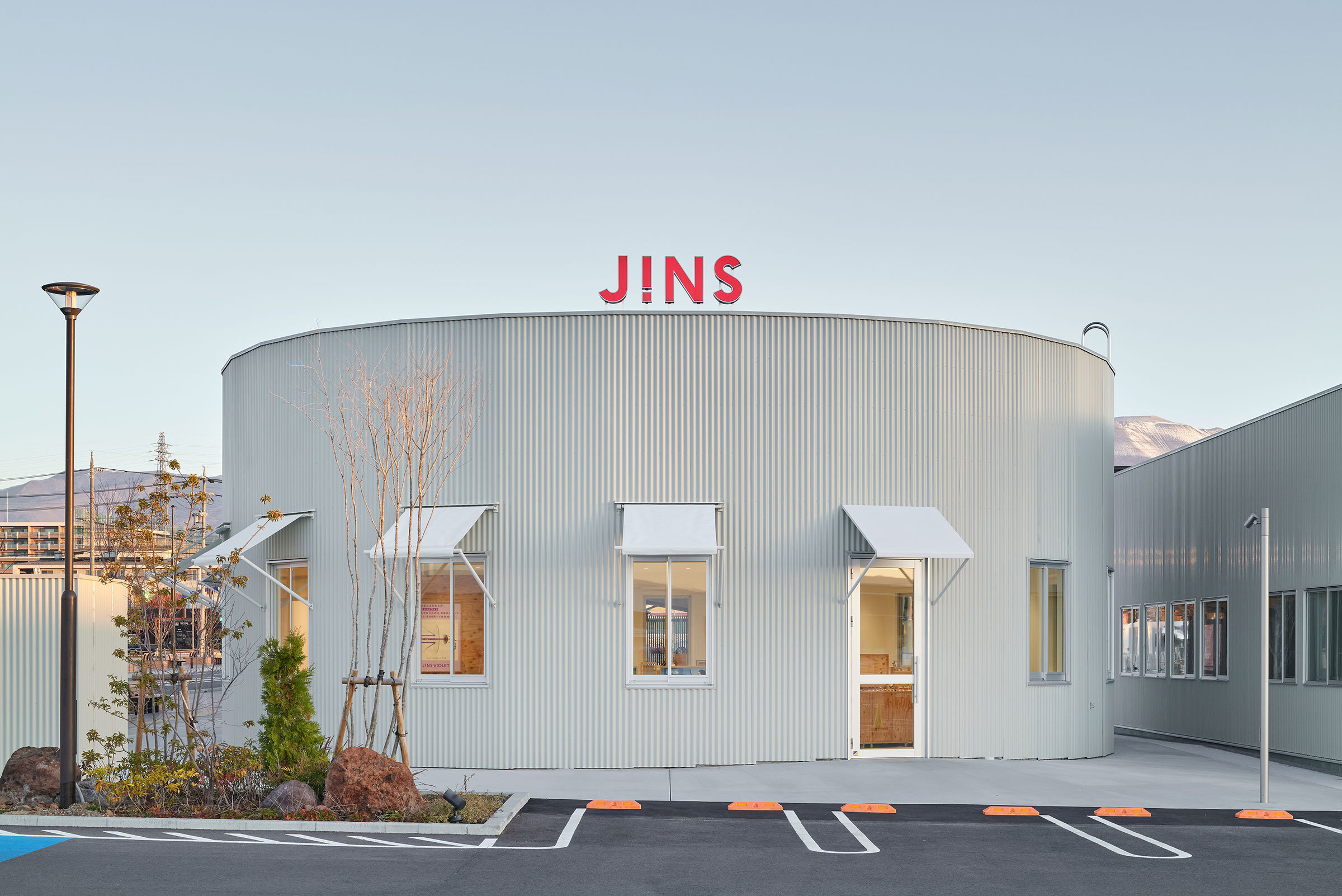 中村竜治建築設計事務所による、長野・佐久市の「JINS佐久平店」。隣接